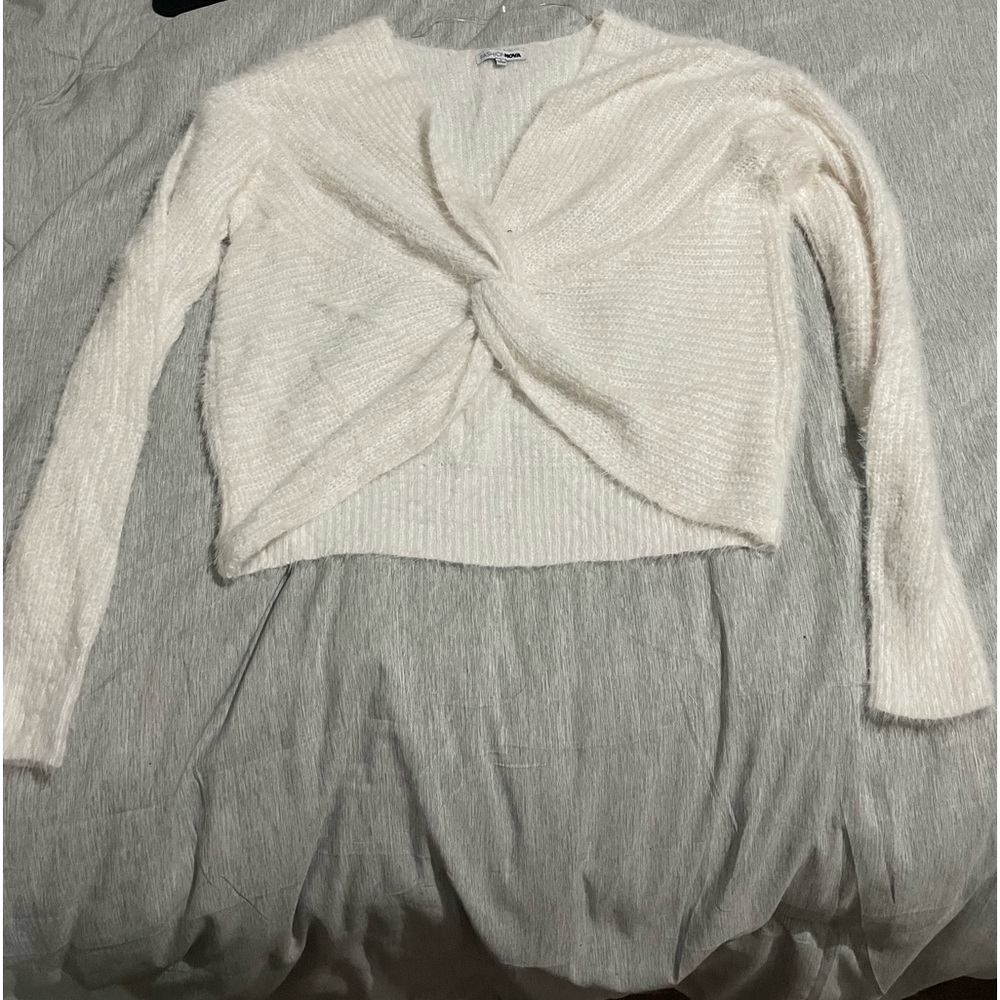 Fuzzy white cropped sweater, hangs off the shoulders.